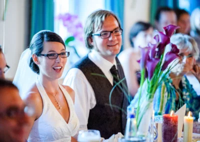 Brautpaar lacht bei Hochzeitsfeier in Gastwirtschaft nordlich von Dachau, festliche Dekoration im Vordergrund.