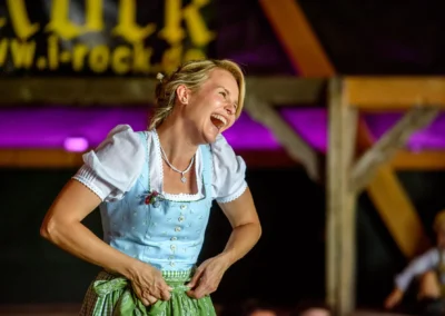 Lachende Frau in Tracht bei einer Hochzeit in Trachtenheim Irschenberg, aufgenommen von Hochzeitsfotograf.