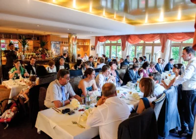 Gäste feiern bei einer Hochzeitsreportage im Hotel Seehof, Wessling. Hochzeitstafel mit gedeckten Tischen.