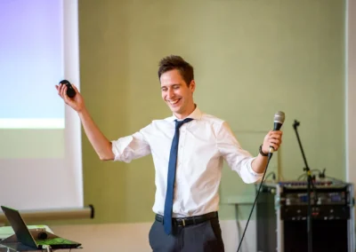 Mann haelt Mikrofon und Fernbedienung waehrend Hochzeitsfeier in Orangerie Ansbach. Hochzeitsreportage westlich von Nuernberg.