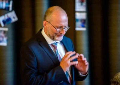 Mann im Anzug lacht bei einer Hochzeitsfeier in der Orangerie Ansbach, Hochzeitsreportage von Hochzeitsfotograf.