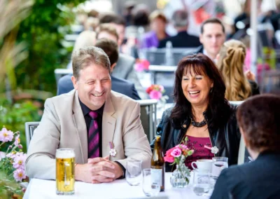 Gäste lachen bei einer Hochzeit auf dem Augustlhof Pfettrach, festgehalten von einem Hochzeitsfotografen.