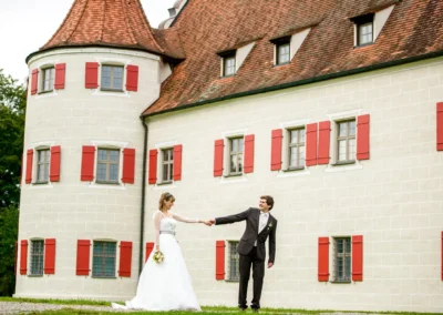 Brautpaar tanzt vor Schloss Grunau, Hochzeitsfoto nahe Ingolstadt, stilvolles Brautpaarshooting im Freien.