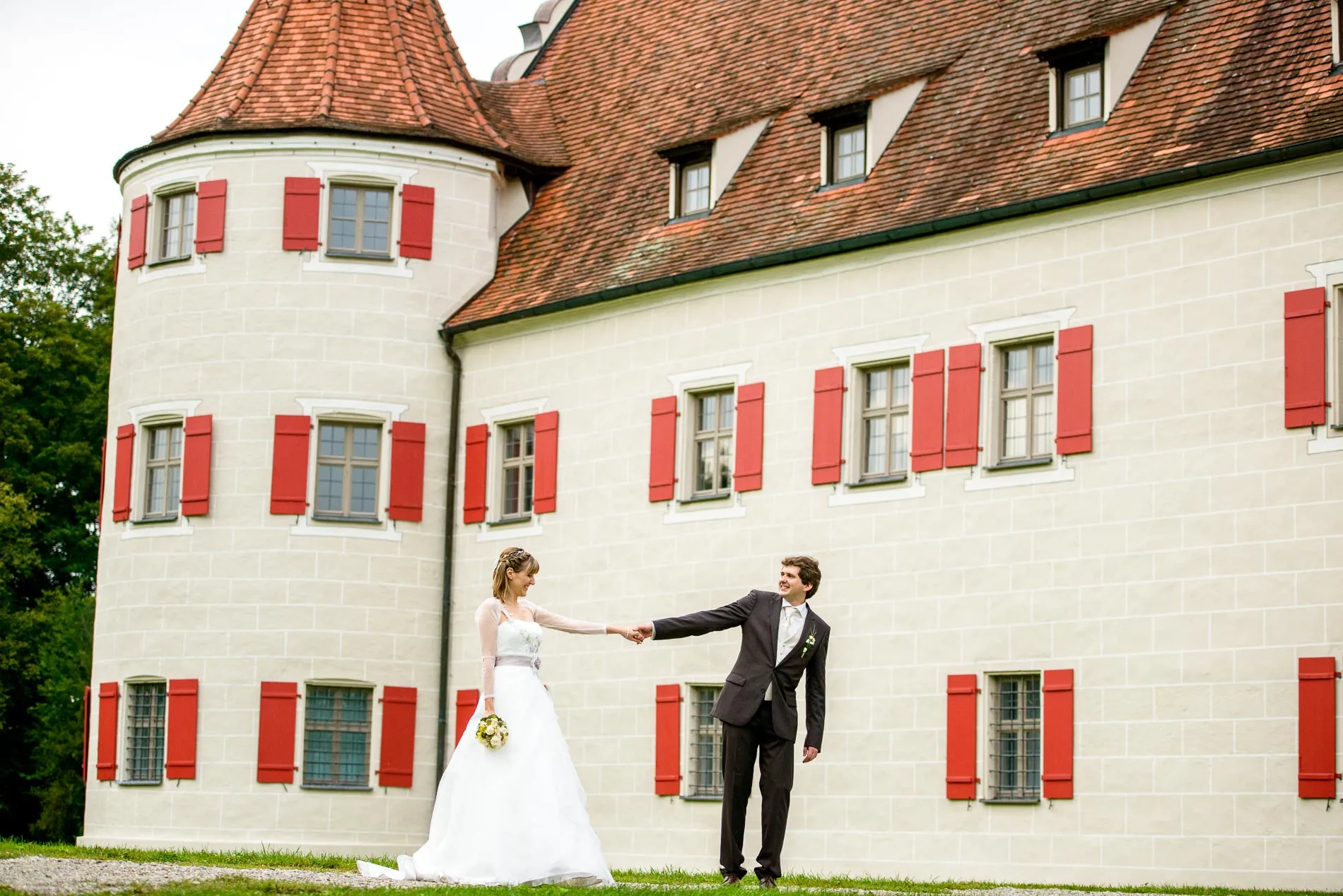 Brautpaar tanzt vor Schloss Grunau, Hochzeitsfoto nahe Ingolstadt, stilvolles Brautpaarshooting im Freien.