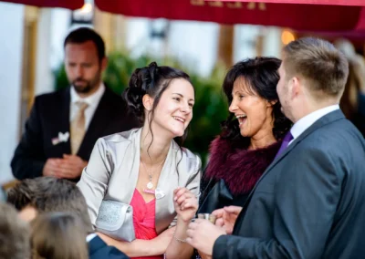 Gäste lachen fröhlich bei der Hochzeit in Pfettrach. Hochzeitsfotografie fängt emotionale Momente ein.