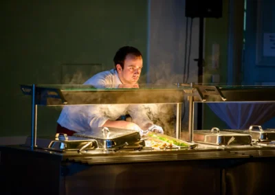Koch am Buffet bei einer Hochzeitsfeier in der Orangerie Ansbach. Festliche Hochzeitsfotoreportage.