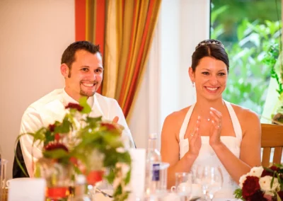 Bräutigam und Braut klatschen lächelnd im Hotel Langwieder See bei ihrer Hochzeitsfeier.