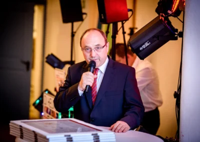 Ein Mann im Anzug spricht bei einer Hochzeit im Jagdschloss Gruenau nahe Ingolstadt ins Mikrofon.