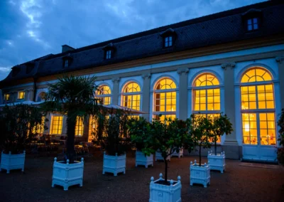 Außenansicht der beleuchteten Orangerie Ansbach, geeignet für Hochzeitsfotografie bei Sonnenuntergang.