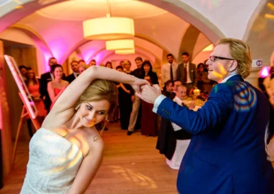 Tanzendes Brautpaar bei Hochzeitsfeier in Pfettrach, umgeben von applaudierenden Gästen, aufgenommen vom Hochzeitsfotografen.