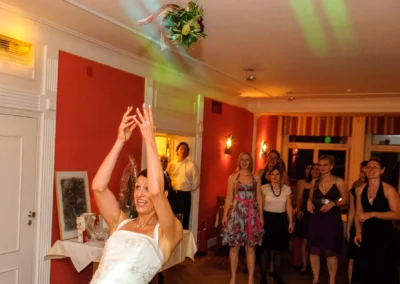 Braut wirft Blumenstrauss bei Hochzeit, Gaeste schauen zu, Hochzeitsszene in Muenchen Langwieder See.