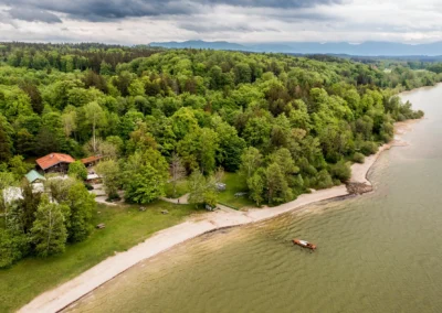 Luftaufnahme des Buchscharner Seewirts am Starnberger See mit gruenem Wald und Ufer. Perfekt fuer eine Hochzeitsreportage.