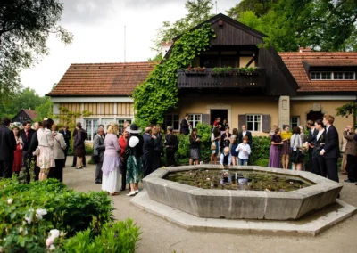 Gartenempfang einer Hochzeit am Kuünstlerhaus Gasteiger, Gaeste versammeln sich am Teich, Hochzeitsreportage.