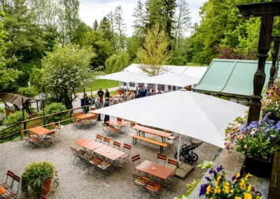 Hochzeitsfeier im Freien mit Gaesten unter Sonnenschirmen, Buchscharner Seewirt, Hochzeitsfotografie.