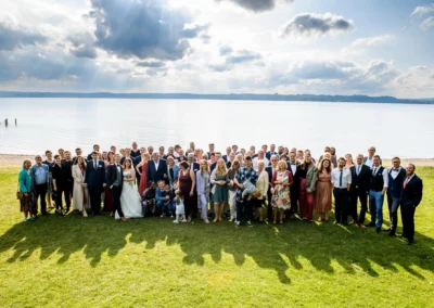 Hochzeitsfoto mit großem Gruppenfoto am Starnberger See, aufgenommen bei einer Hochzeit im Landkreis Bad Toelz-Wolfratshausen.