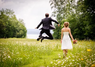 Brautpaar beim Spaziergang durch blühende Wiese, Hochzeitsfoto Künstlerhaus Gasteiger am Ammersee.