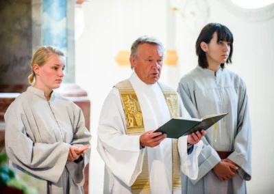 Priester bei kirchlicher Trauung mit zwei Assistenten in Kirchheim. Hochzeitsfotografie nahe Muenchen.