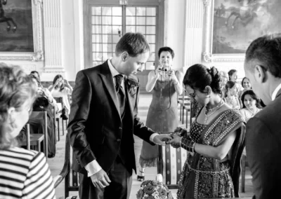 Brautpaar tauscht Ringe waehrend der standesamtlichen Trauung in Schleissheim bei Muenchen, Hochzeitsfoto authentisch.
