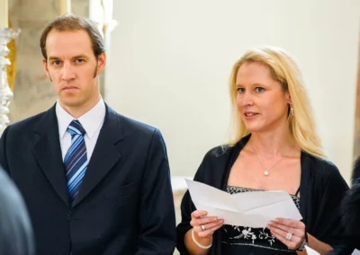 Brautjungfer liest in Kirche nahe Muenchen eine Rede, begleitet vom Bräutigam während der Hochzeitszeremonie.