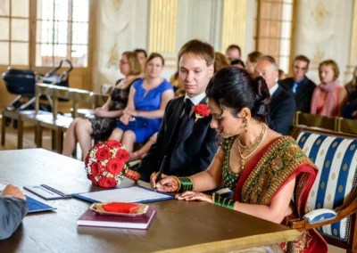 Brautpaar bei standesamtlicher Trauung im Schloss Schleissheim, Braut unterschreibt, Hochzeitsreportage nördlich Muenchen.