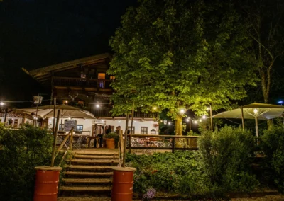 Nachtaufnahme einer Hochzeit bei Buchscharner Seewirt, Starnberger See, beleuchteter Außenbereich und Bäume.