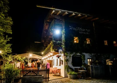 Gartenhochzeit bei Buchscharner Seewirt am Abend, festliche Beleuchtung, Gaeste geniessen Hochzeitsatmosphaere.