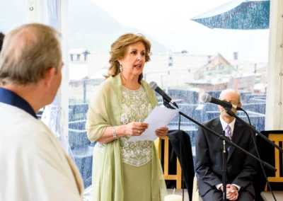 Eine Frau in elegantem Kleid spricht in ein Mikrofon, während ein Mann im Anzug zuhört.