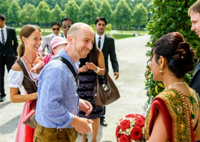 Gäste begrüßen Braut bei standesamtlicher Trauung in Schleissheim, Nähe München. Hochzeitsfotografie im Freien.