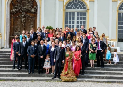 Gruppe von Hochzeitsgaesten und Brautpaar vor Schloss Schleissheim nach standesamtlicher Trauung bei Hochzeit.
