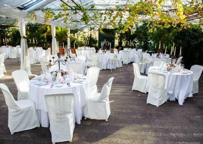 Runde Hochzeitstische mit weißen Tischdecken in alter Gaertnerei Taufkirchen nahe Muenchen, Hochzeitseinrichtung.