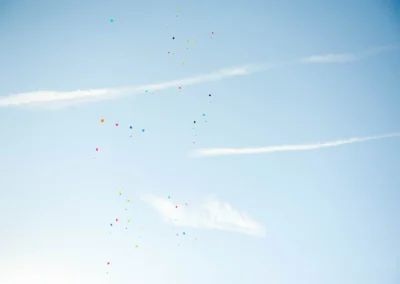 Bunte Luftballons steigen bei einer Hochzeitsfeier in Taufkirchen bei Muenchen in den blauen Himmel auf.