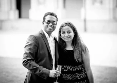 Paar posiert bei Hochzeit im Schlosspark Schleissheim, der Mann haelt ein Glas. Hochzeitsreportage in Schwarz-Weiss.