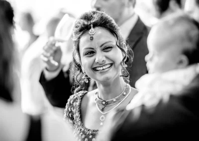 Lachende Frau bei Hochzeit im Schlosspark Schleissheim, mit Kind im Vordergrund. Hochzeitsfotografie bei Muenchen.