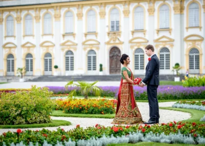 Brautpaar vor Schlosspark Schleissheim, umgeben von bunten Blumen. Hochzeitsfoto im barocken Ambiente nördlich Muenchen.