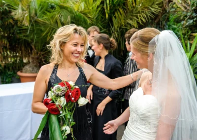 Braut und Gaeste im Garten bei Hochzeitsreportage in alte gaertnerei Taufkirchen bei Muenchen.