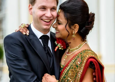 Brautpaar umarmt sich vor dem Schloss Schleissheim, Hochzeitsportraits in nördlich Muenchen. Farbenfrohe Hochzeitsfotografie.