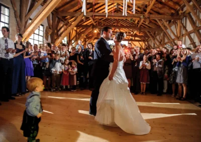 Ein Brautpaar tanzt inmitten feiernder Hochzeitsgäste iim Eventstadl zur Alten Säge in Moosach bei Grafing.