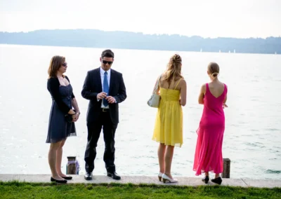 Hochzeitsgaeste am Starnberger See mit elegantem Hintergrund, aufgenommen bei einer Hochzeit im Seehotel Leoni.