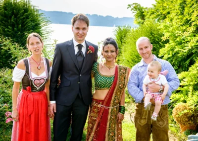 Gruppenfoto bei Hochzeit im Freien, Seehotel Leoni, mit traditioneller Kleidung und Hintergrund Landschaft.
