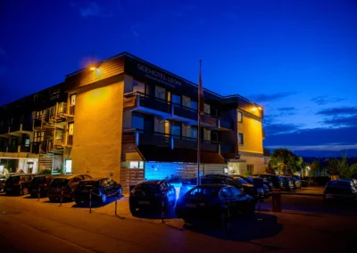 Seehotel Leoni bei Nacht, beleuchtet in Blau und Gelb. Hochzeitstag am Starnberger See, suedlich von Muenchen.