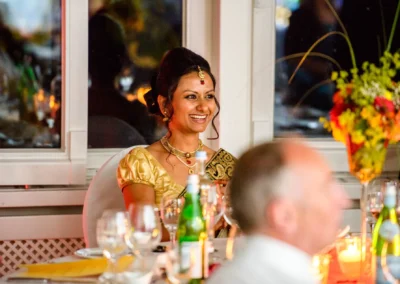 Lachende Frau in festlicher Kleidung bei einer Hochzeit im Seehotel Leoni, Hochzeitsfoto, Kerzenlicht und Blumen.