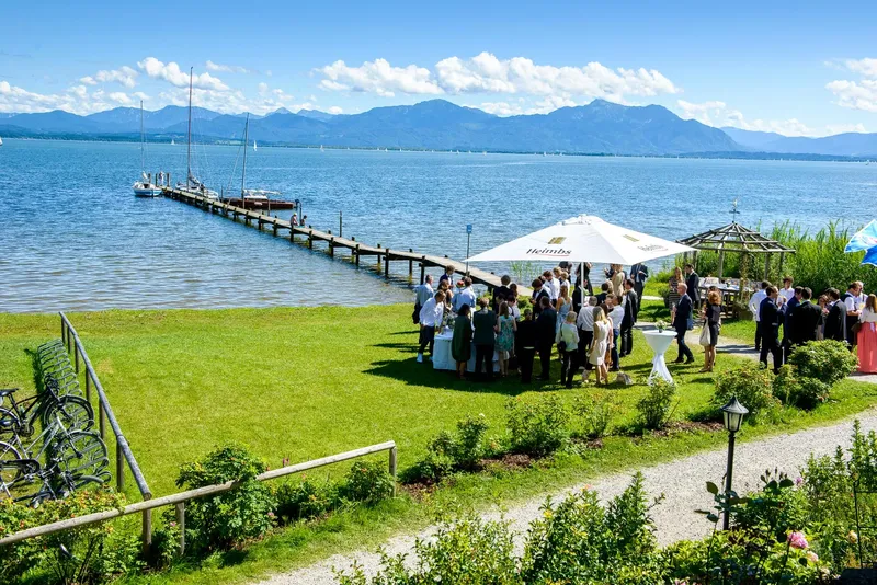 chiemsee-hochzeitsfeier_4 Weitläufige Aufnahme einer Chiemgau-Hochzeit mit Blick auf das bayerische Meer.