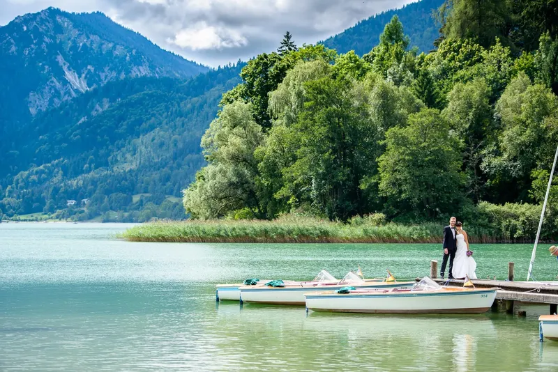 heiraten-in-oberbayern_2 Brautpaar auf einem rustikalen Holzsteg am Schliersee in Oberbayern